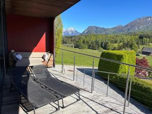 a chair on a balcony with a view of the mountains at PurPlus Lodge in Vorderstoder
