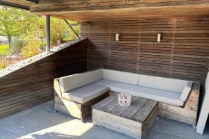 a bench on a patio with a wooden wall at PurPlus Lodge in Vorderstoder