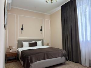 ein Schlafzimmer mit einem Bett und einem großen Fenster in der Unterkunft Vila Verde in Chişinău