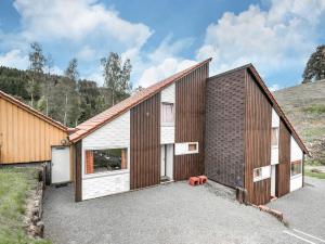 a house with two garage doors and a driveway at Cosy holiday home in the Hochsauerland with terrace at the edge of the forest in Schmallenberg