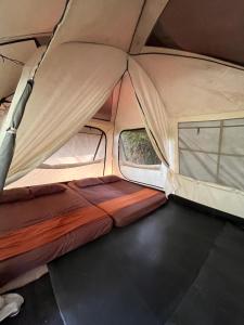 a tent with a bed and two windows in it at serlok glamping in Tangkubanperahu