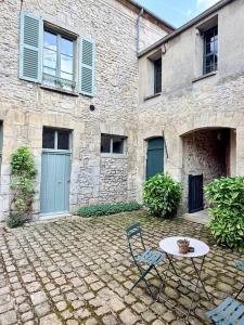 a table and chairs in front of a building at Appartements 56 in Senlis