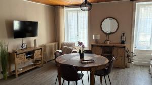 a living room with a table and a television at Gîte NAO in Serves-sur-Rhône