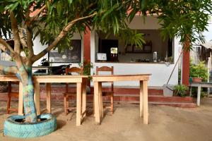 a wooden table sitting next to a tree at CDAC Elijah - Espace Culturel in Ouidah