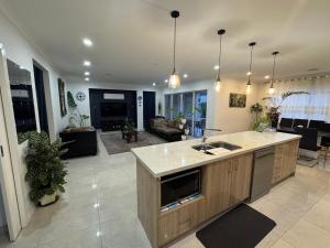 a kitchen and living room with a sink and a counter at Cozy and comfortable room - Geelong suburbs in Grovedale