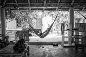 a person is swinging in a hammock in a room at CDAC Elijah - Espace Culturel in Ouidah