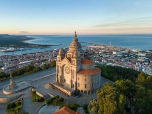 a building with a clock tower in front of a city at Republica Vintage House in Viana do Castelo