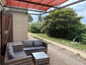 a patio with a couch and a table at Maison de l'Hermitage in Cucuron