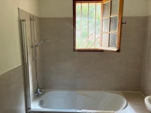 a white tub in a bathroom with a window at Maison de l'Hermitage in Cucuron +17 photos