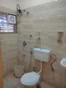 a bathroom with a toilet and a sink at MVTJ Hotel in Bangalore