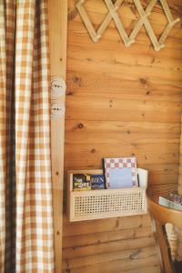 a room with a wooden wall with a shelf with books at Le Chalet du Michel in Hardifort