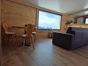 a living room with a couch and a large window at Seilbahnstubli in Ibergeregg