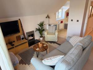 a living room with a couch and a tv at Ballard Down View, Swanage 2 Bed in Swanage