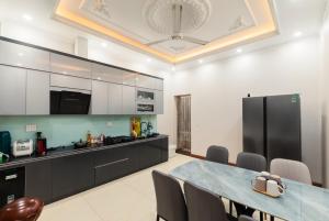 a kitchen with a table and a black refrigerator at Willow Stay in Hai Phong