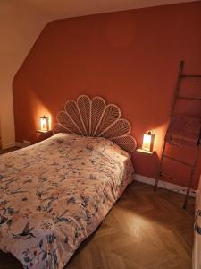 a bedroom with a bed with two lights on the wall at Cosy travels in Les Andelys