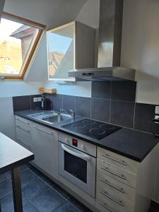 a kitchen with a sink and a stove top oven at Cosy travels in Les Andelys