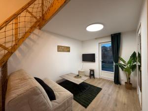 a living room with a couch and a window at suite Jacuzzi terrasse privé parking in Caligny