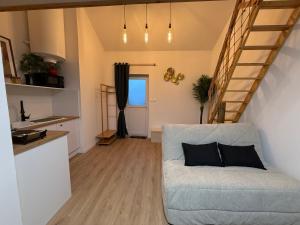 a living room with a couch and a staircase at suite Jacuzzi terrasse privé parking in Caligny
