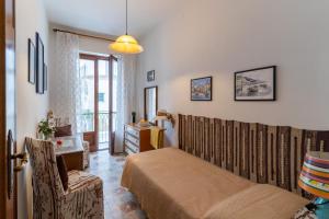 a bedroom with a bed and a chair and a window at CristallPont AmalfiDay in Atrani
