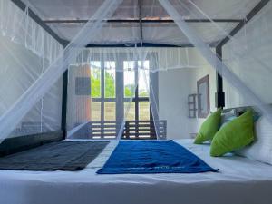 a bedroom with a bed with a blue blanket on it at Home in the Island in Tangalle +89 photos