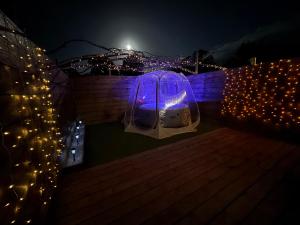 a tent in the water at night with lights at suite Jacuzzi terrasse privé parking in Caligny
