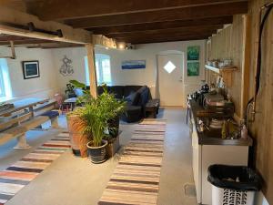 a living room with a couch and some plants in it at Ner-Grefstad gard in Kallstad