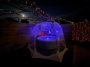 a jacuzzi tub with lights on a fence at suite Jacuzzi terrasse privé parking in Caligny