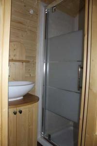 a glass shower in a bathroom with a sink at Camping Le Sans Souci in Fresnay-sur-Sarthe