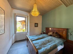 a bedroom with a bed and a chandelier at Casa Claudia Pieve centro storico in Tremosine Sul Garda