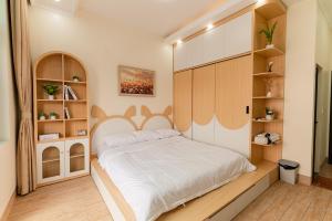 a bedroom with a large bed with a wooden headboard at Willow Stay in Hai Phong