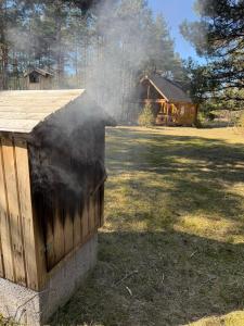 a pile of smoke coming out of a wooden house at Nature Getaway Holiday Home in Mujaste