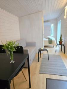 a living room with a table with a vase on it at Seaside cottage with private beach & wood-fired sauna in Vörå, Finland in Oravais +93 photos