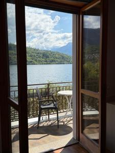 a balcony with a table and a chair looking out at a lake at Albergo Mezzolago in Calceranica al Lago