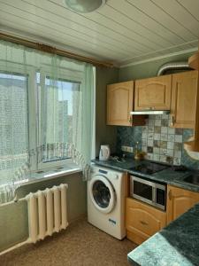 a kitchen with a washing machine and a window at Teatra 34-31 in Daugavpils