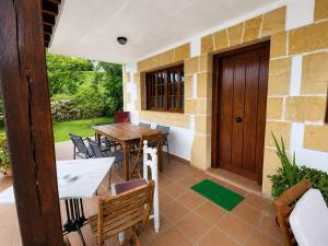 a patio with a table and chairs and a wooden door at Posada Adela in Santillana del Mar