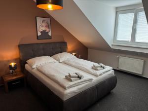 a bedroom with a bed with two towels on it at Penzión ACCOM in Trenčín