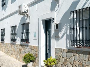 a white building with a door and balcony at Casa isabel in Setenil