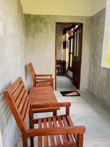 two wooden benches sitting in the hallway of a house at Home in the Island in Tangalle