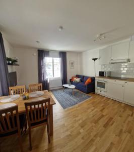 a kitchen and living room with a table and a couch at Central City Apartment A in Nyköping