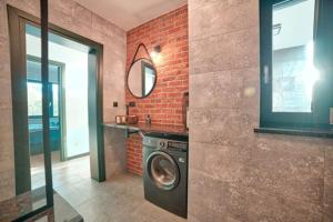 a washing machine in a bathroom with a brick wall at Willa Gostomko in Gostomko