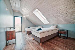 two beds in a room with a wooden ceiling at Willa Gostomko in Gostomko