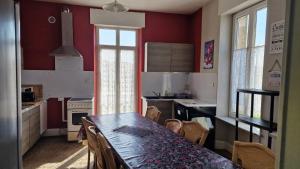 a kitchen with a table and chairs in a room at Gîte chez la Marie in Épinal