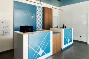 a lobby with a reception desk with blue and white at Four Points Flex by Sheraton Malaga Centre in Málaga