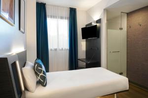 a hotel room with a white bed and a window at Four Points Flex by Sheraton Malaga Centre in Málaga