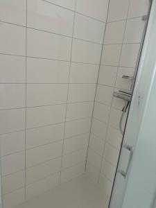 a bathroom with a shower with white tiles at Hostellerie de la juhel in Villaines-la-Juhel
