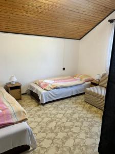 a room with two beds and a chair in it at Dombi-Lak in Tiszakécske