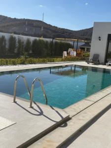 a large swimming pool with blue water at Houseselect in Nador