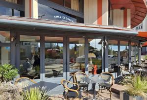 a cafe with tables and chairs in front of a building at Cit' Hôtel Agena in Brest