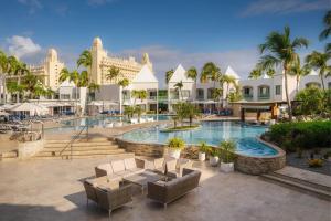 a pool at the resort with palm trees and buildings at Courtyard by Marriott Aruba Resort in Palm-Eagle Beach