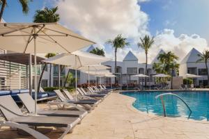 a pool at the resort with lounge chairs and umbrellas at Courtyard by Marriott Aruba Resort in Palm-Eagle Beach